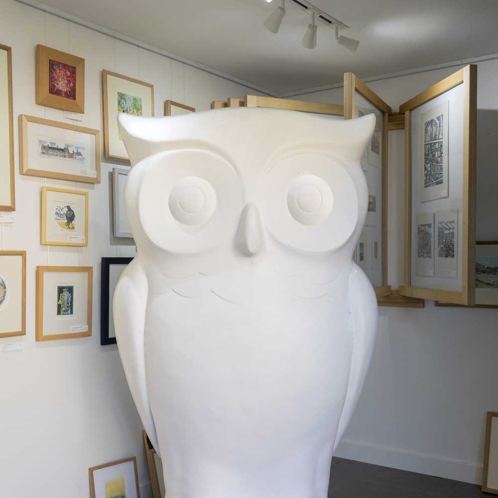 Plain white owl sculpture inside Come Hither Gallery