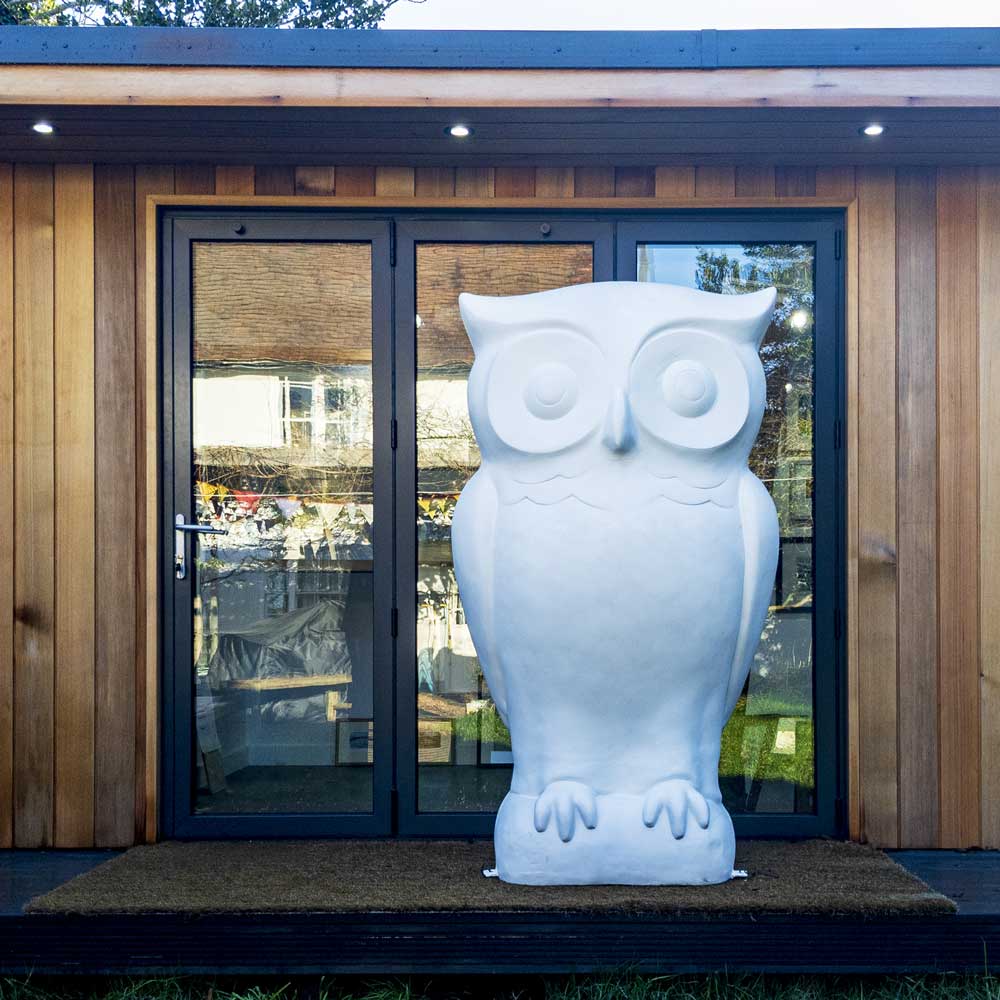 Plain white owl sculpture outside Come Hither Gallery
